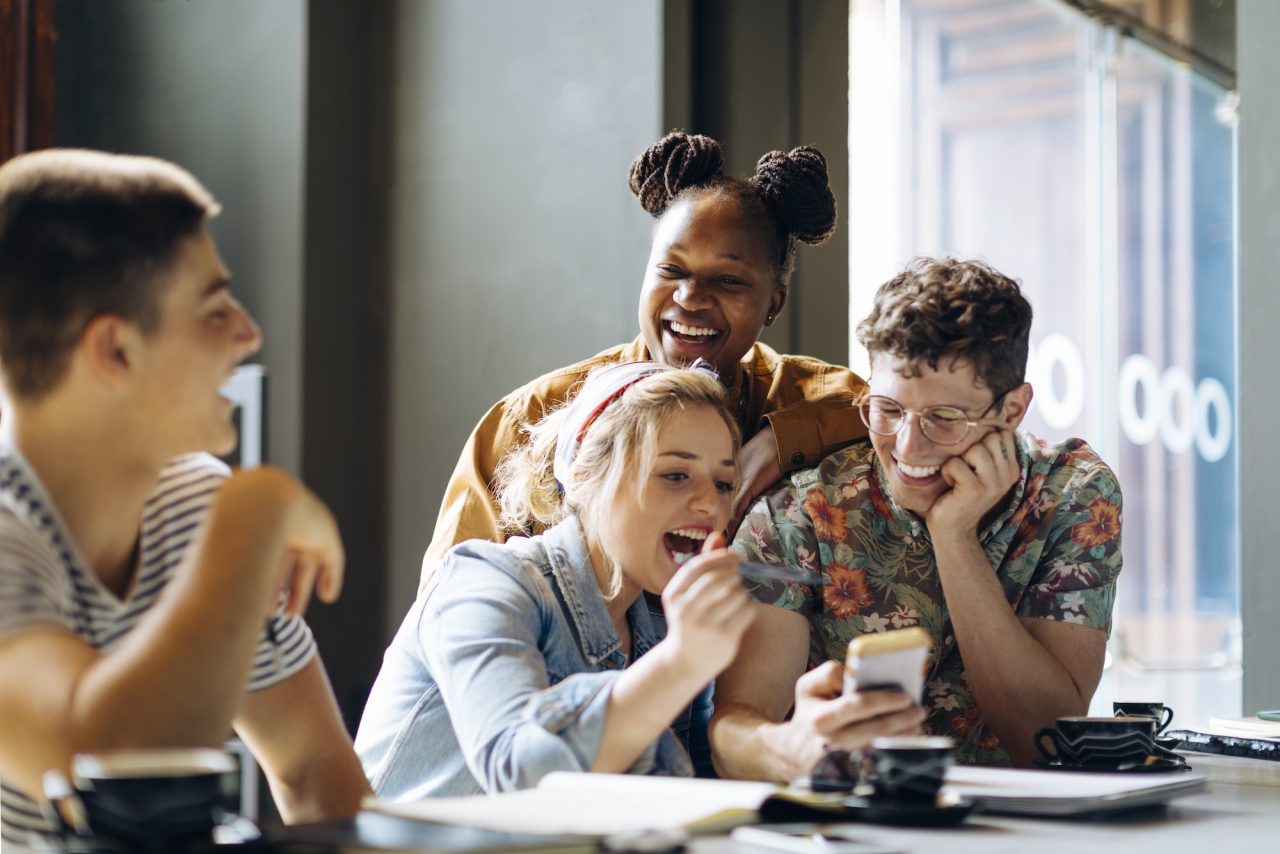 Students Meeting In Cafe Learning Together Using Laptop And Smartphones